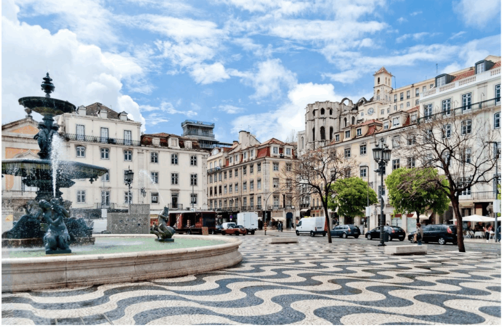 Rossio Square with a fountain and black and white wavy tiled ground in Lisbon