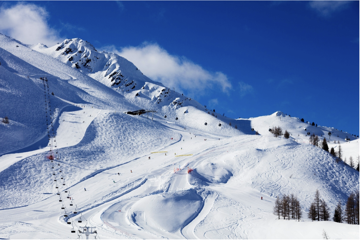 A ski resort with snow, ski lifts, and skiers in the French Alps